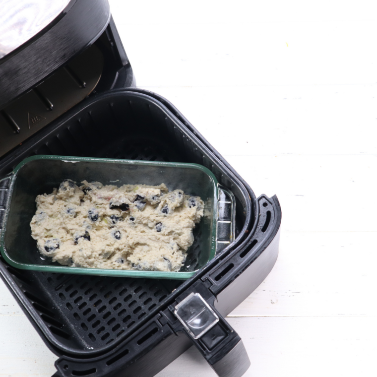 Loaf pan of air fryer blueberry pound cake in the air fryer basket