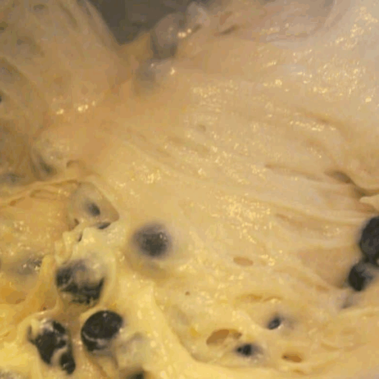 Mixing eggs, vegetable oil, vanilla, and sugar with flour, leavening, cinnamon, zucchini, and blueberries in a large bowl to prepare blueberry zucchini bread batter.