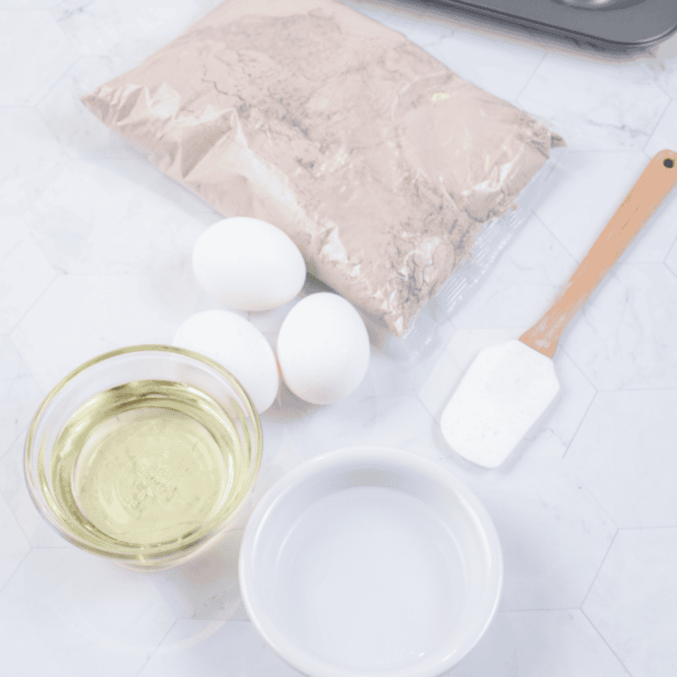 Ingredients for 3-ingredient air fryer brownie bites: brownie mix, eggs, and oil.