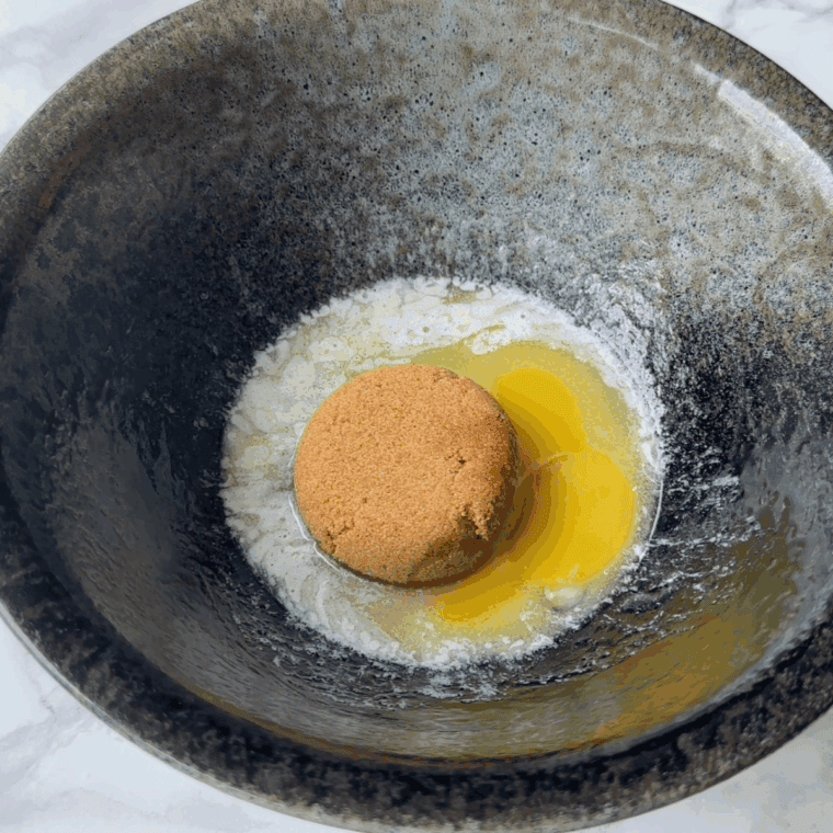 Mixing flour, sugar, cocoa, baking soda, and baking powder in a bowl