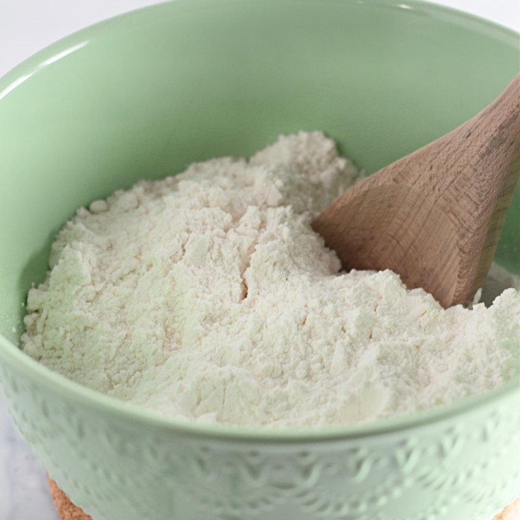 Ingredients for air fryer raspberry bread: flour, sugar, butter, eggs, sour cream, milk, and fresh raspberries in bowls