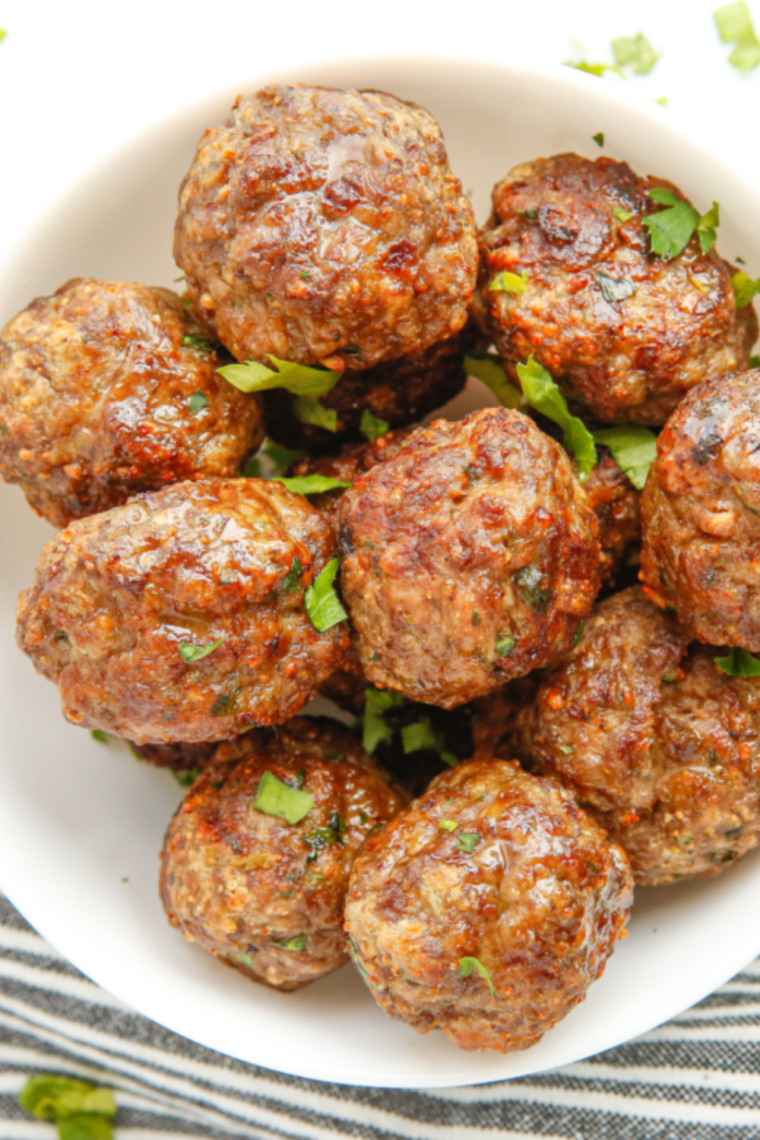 Air fryer BBQ meatballs coated in sticky caramelized sauce served hot and juicy in a bowl.