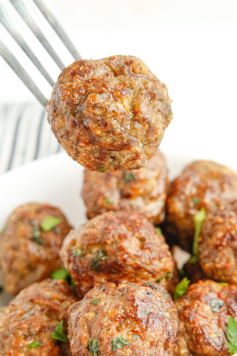Air fryer BBQ meatballs coated in sticky caramelized barbecue glaze served hot and juicy in a bowl.