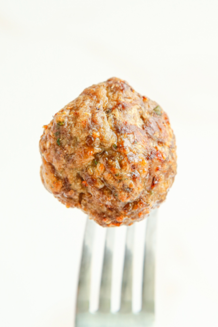 Air fryer BBQ meatballs coated in sticky caramelized barbecue sauce served hot and juicy in a bowl.