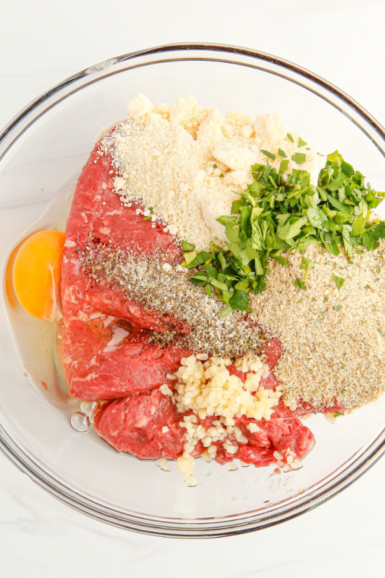 Ground beef combined with soaked breadcrumbs, egg, BBQ sauce, and spices mixed gently until just blended without overworking.