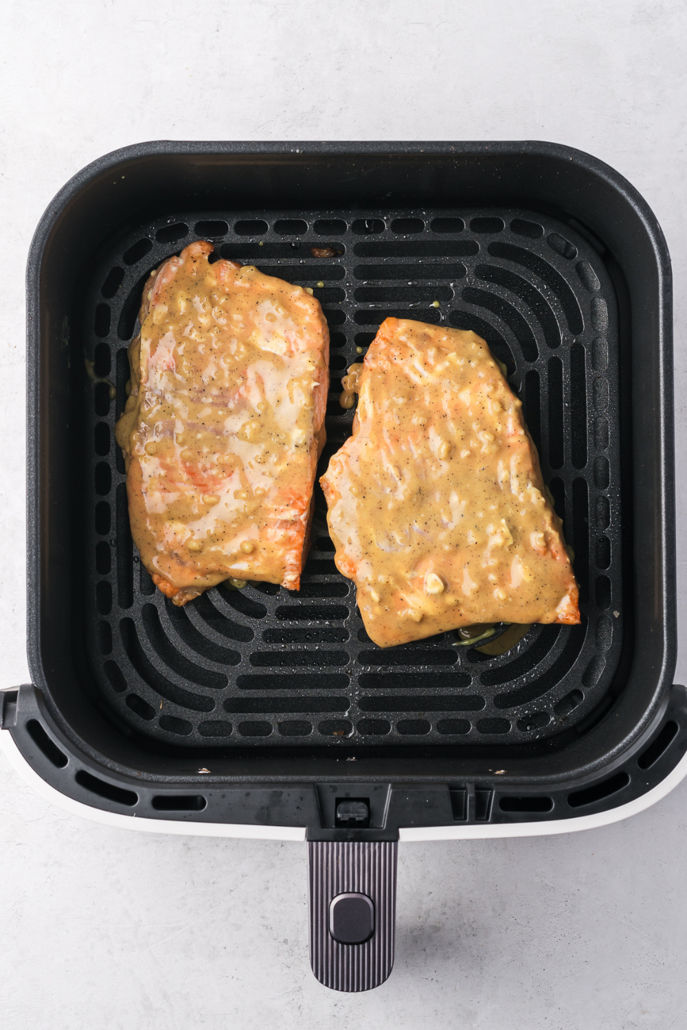 Cooking frozen salmon in the air fryer without thawing resulting in moist flaky fish with crisp edges ready in 16 minutes for fast dinner