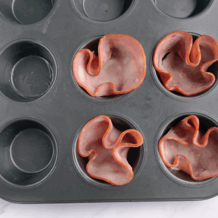 Place the ham into the muffin tin, pressing firmly.
