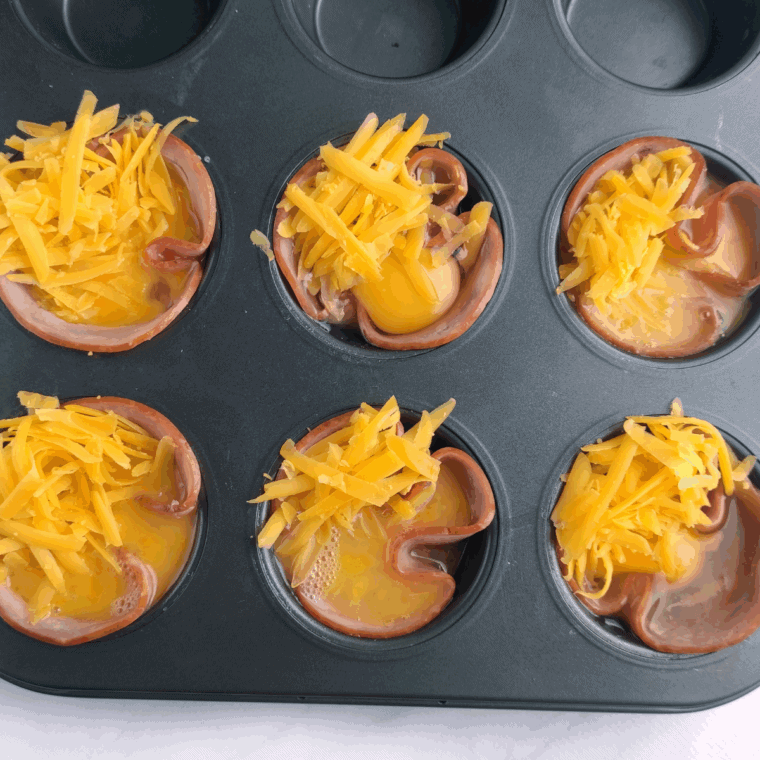 Sprinkle the grated cheese over the tops of the eggs.