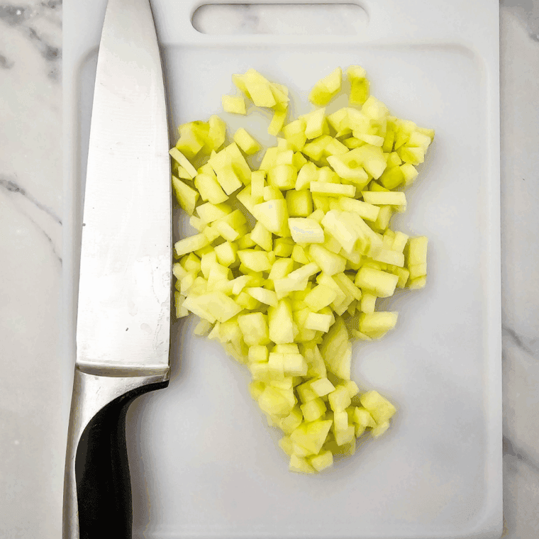 Preheat the air fryer to 320&deg;F. Grease or line an 8x8-inch air fryer-safe pan with parchment paper and lightly coat with nonstick spray. Peel and chop the apple into small pieces.