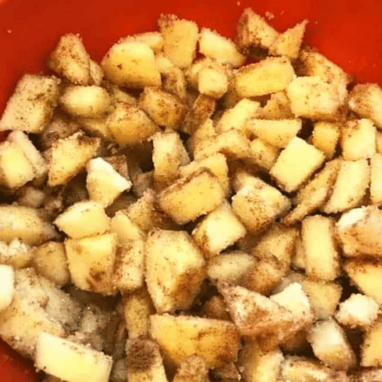 Spoonful of cinnamon apple filling placed in the center of a pie crust circle