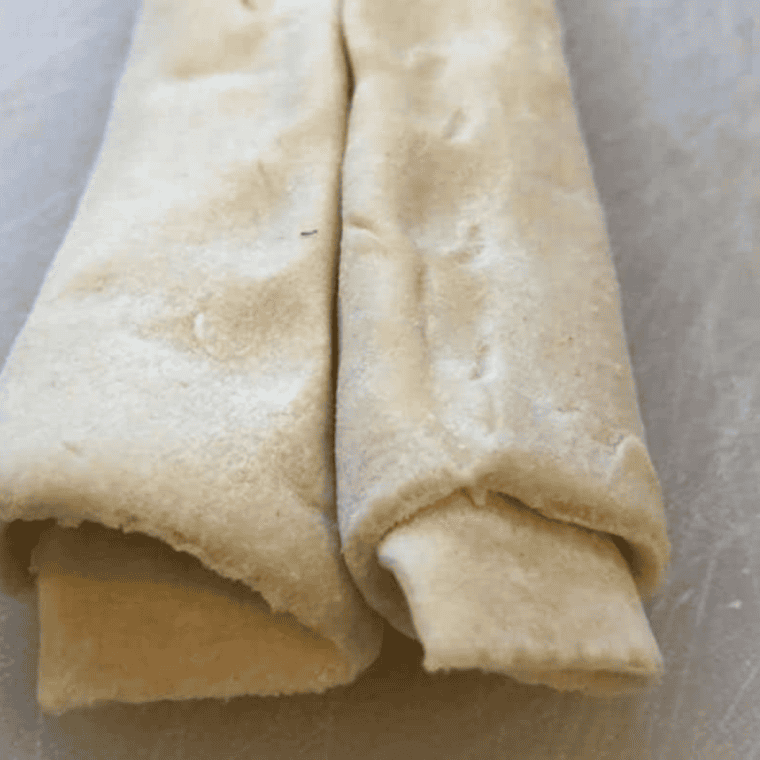 Thawed puff pastry sheet laid flat on surface, sprinkled with granulated sugar.