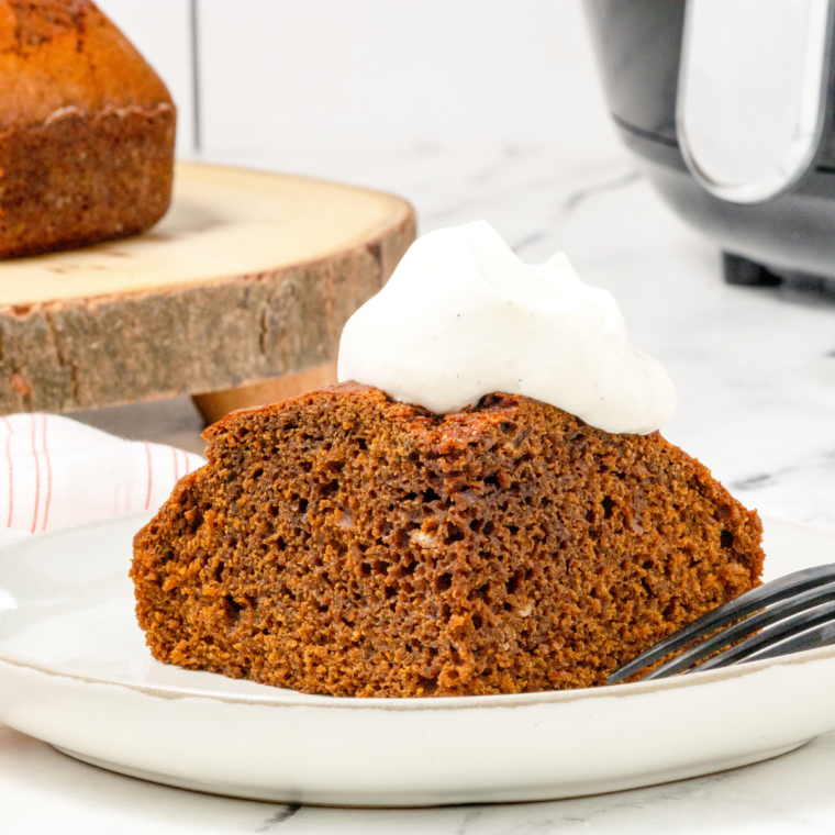 Cream cheese frosting being spread over cooled pumpkin cake