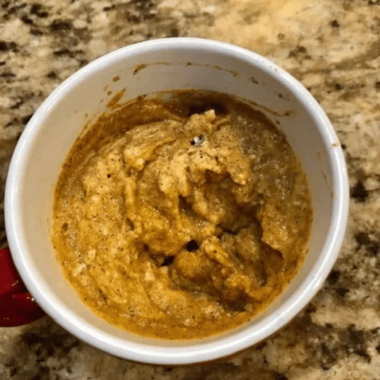 Pumpkin mug cake batter stirred smooth in a mug with a fork, no dry flour remaining