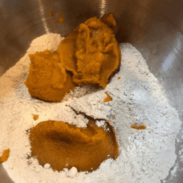 Mixing spice cake mix and canned pumpkin in a large bowl until smooth