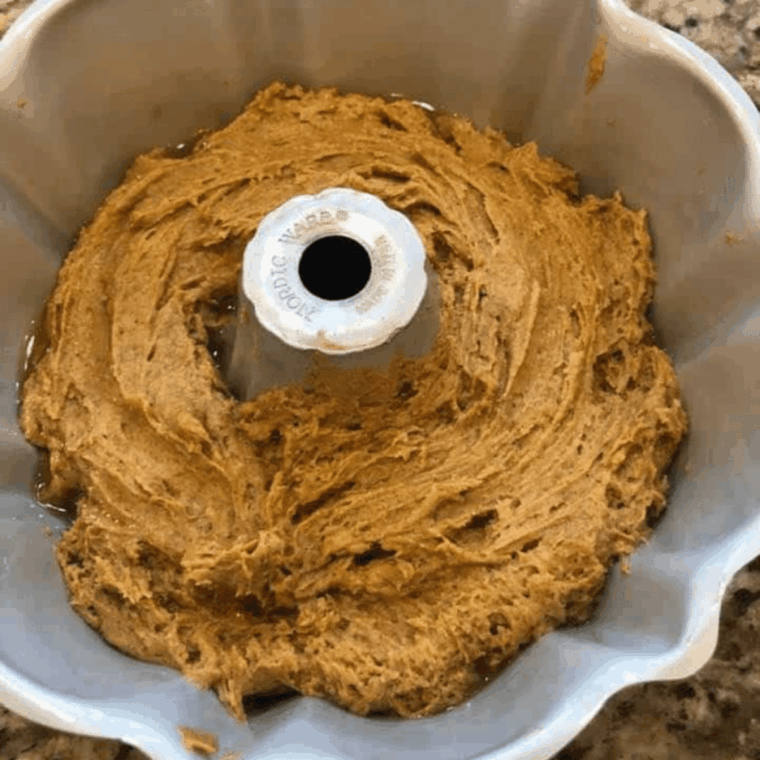 Spraying bundt pan and pouring pumpkin spice batter into pan