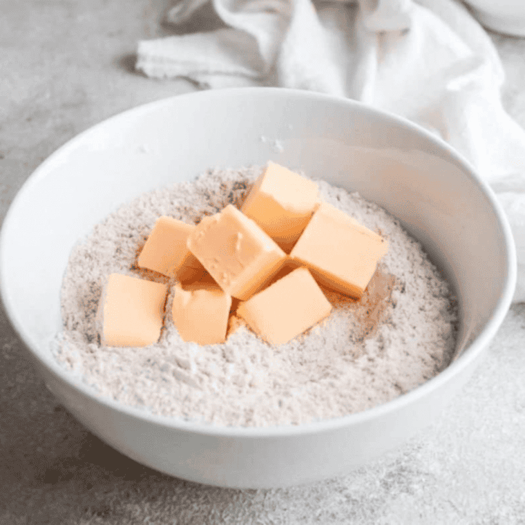 Mixing heavy cream, vanilla, and cherries into scone dough until just combined.