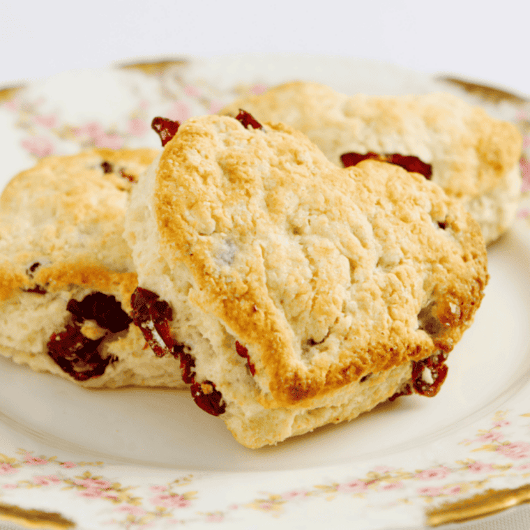 Golden-brown Air Fryer Cherry Scones with visible dried cherries, served on a plate.