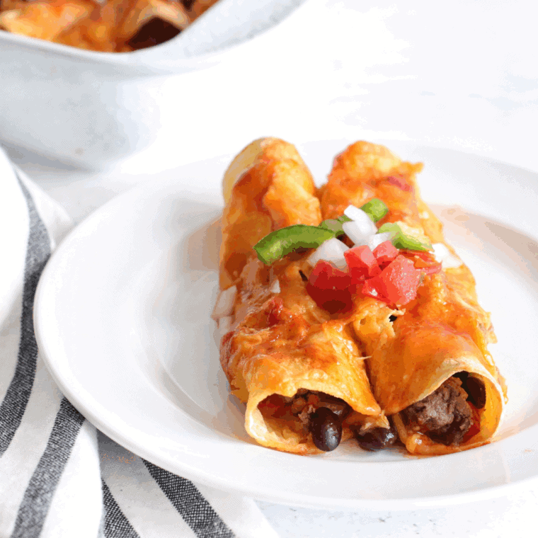 Air fryer enchiladas filled with seasoned ground beef and melted cheese, topped with sauce.