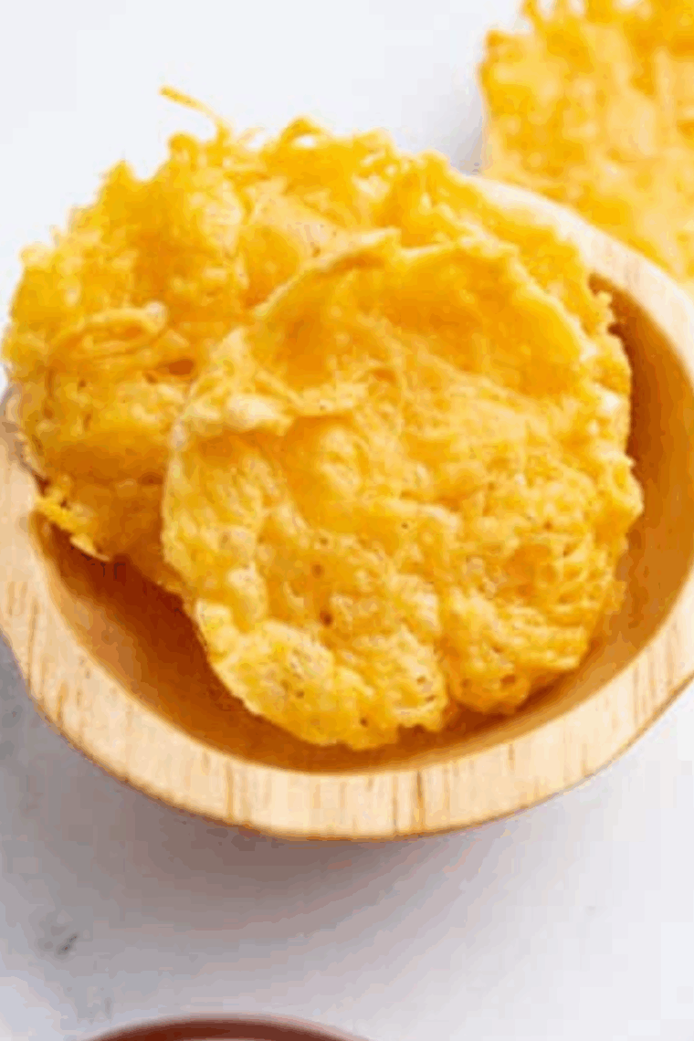 Air fryer Parmesan crisps cooking in a muffin tin, golden and crispy.