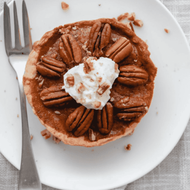 Air fryer pecan pie with glossy pecan topping in a pie dish