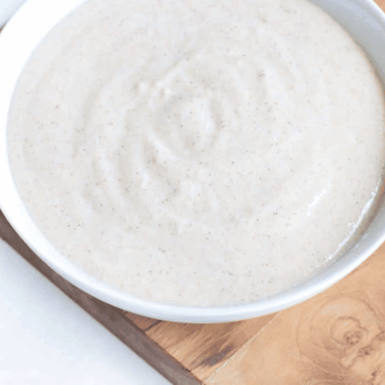 Cheesecake filling being blended in a food processor with cream cheese, apple pie spice, and apple filling.