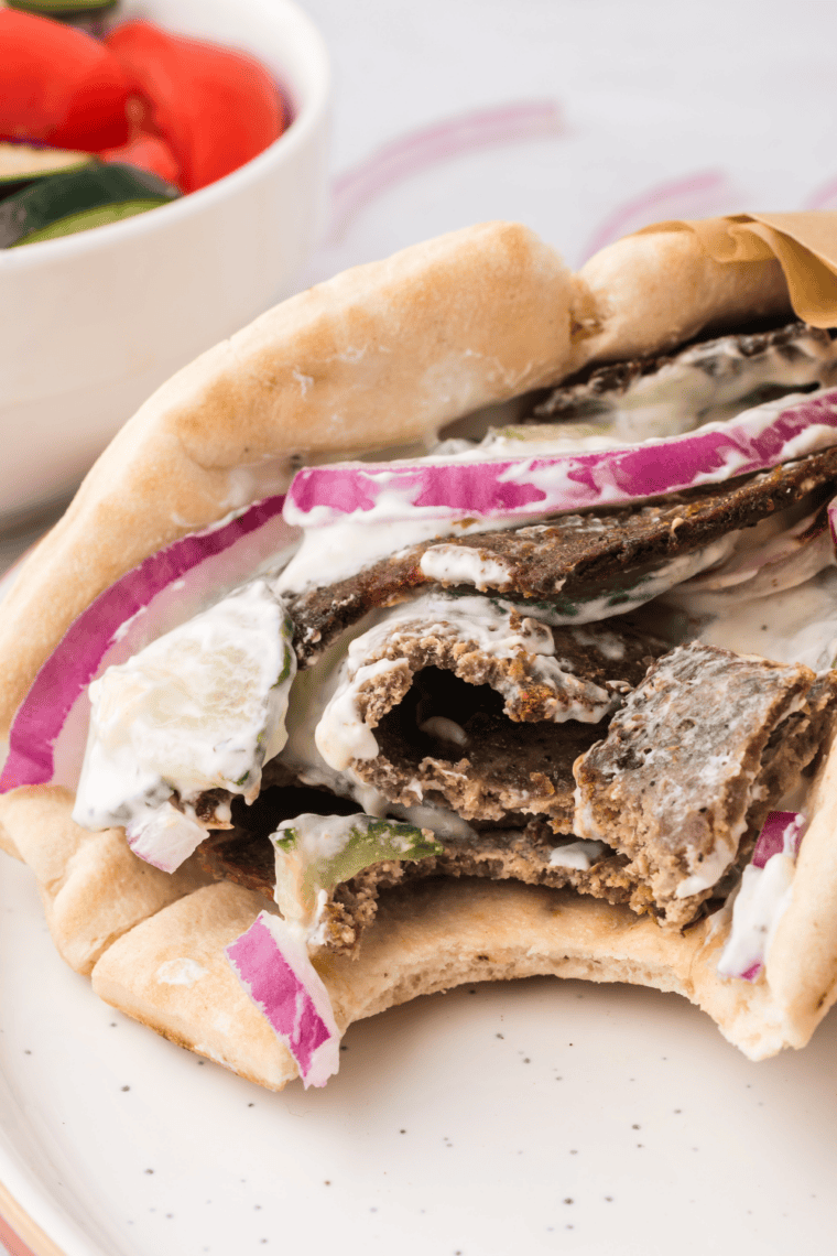 Air fryer beef gyro wrapped in warm pita with tzatziki, tomatoes, and onions.