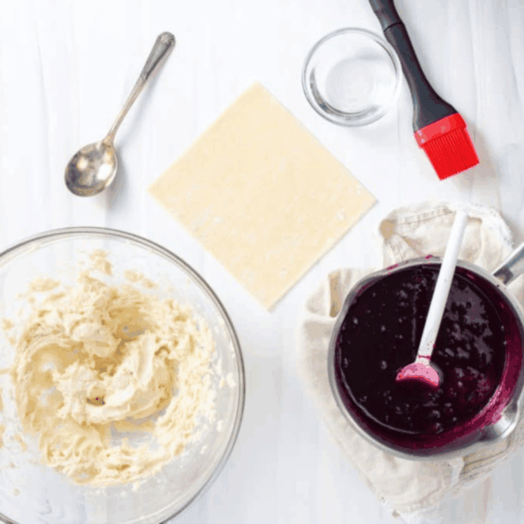 Small saucepan with blueberries, sugar, and lemon juice simmering until thickened and bursting.