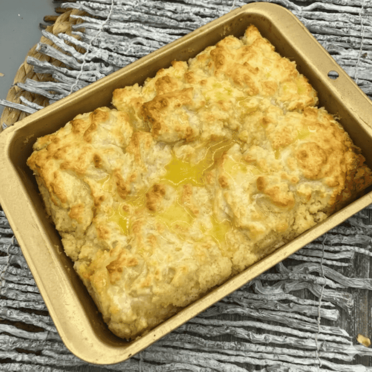 Golden butter swim biscuits baked in the air fryer with melted butter in the pan.
