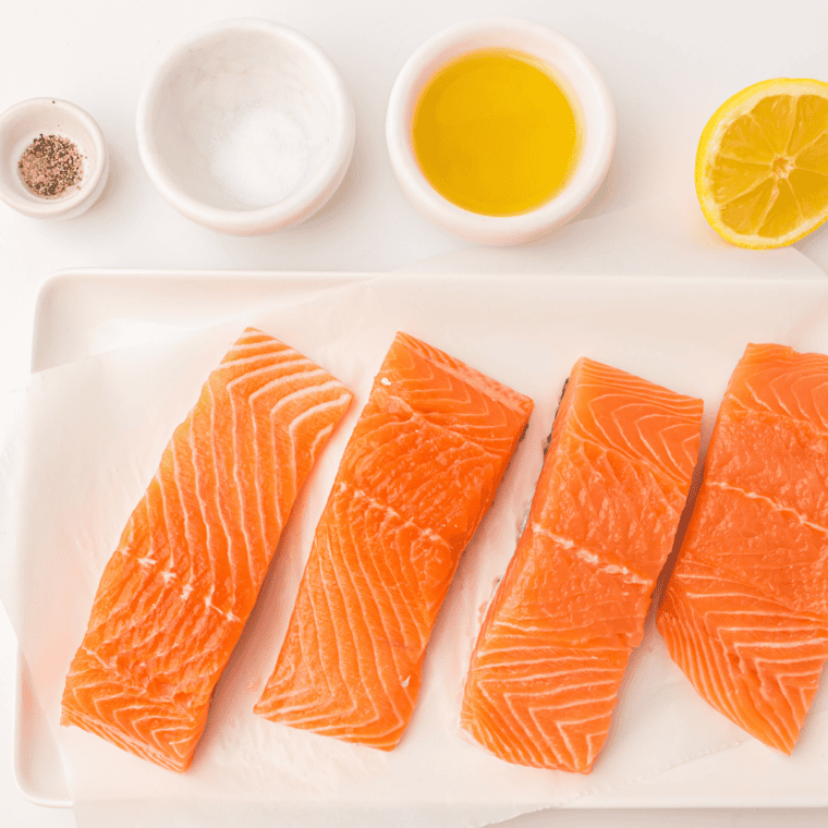 Air fryer lemon Dijon salmon, an easy 20-minute dinner, garnished with fresh lemon wedges