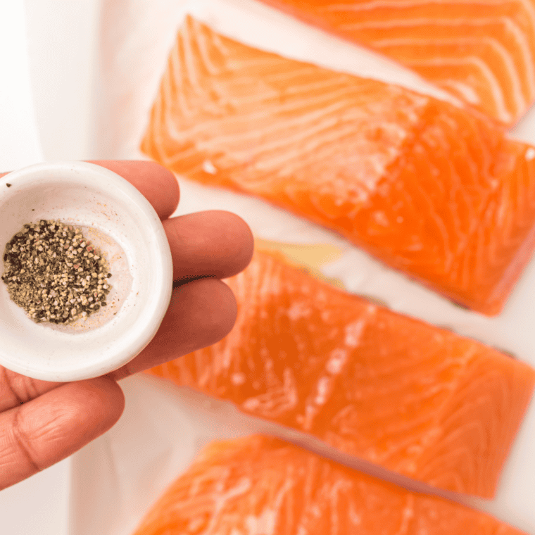 Spreading lemon Dijon sauce over raw salmon fillets before air frying