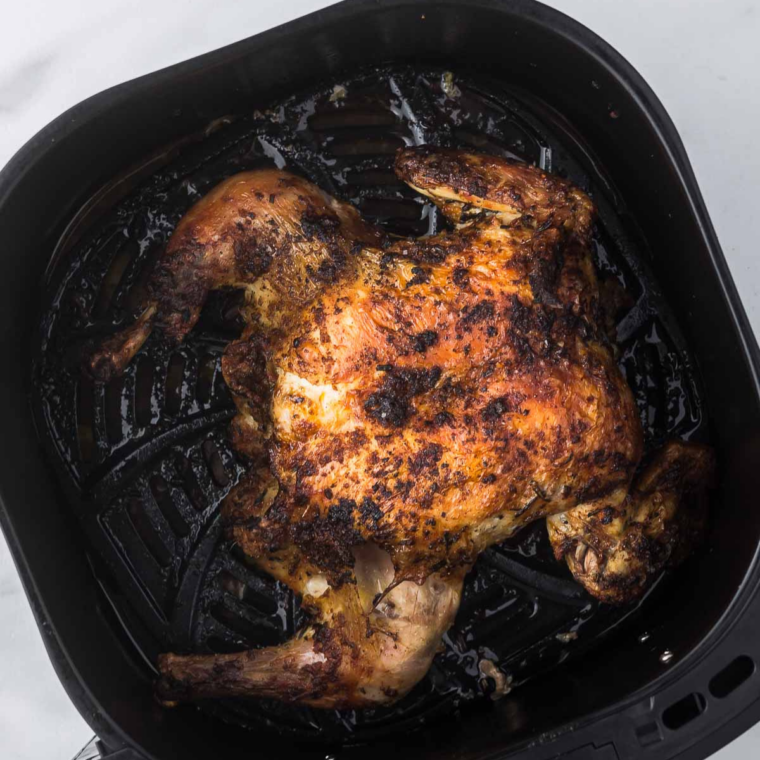 Meat thermometer reading 165°F in spatchcock chicken