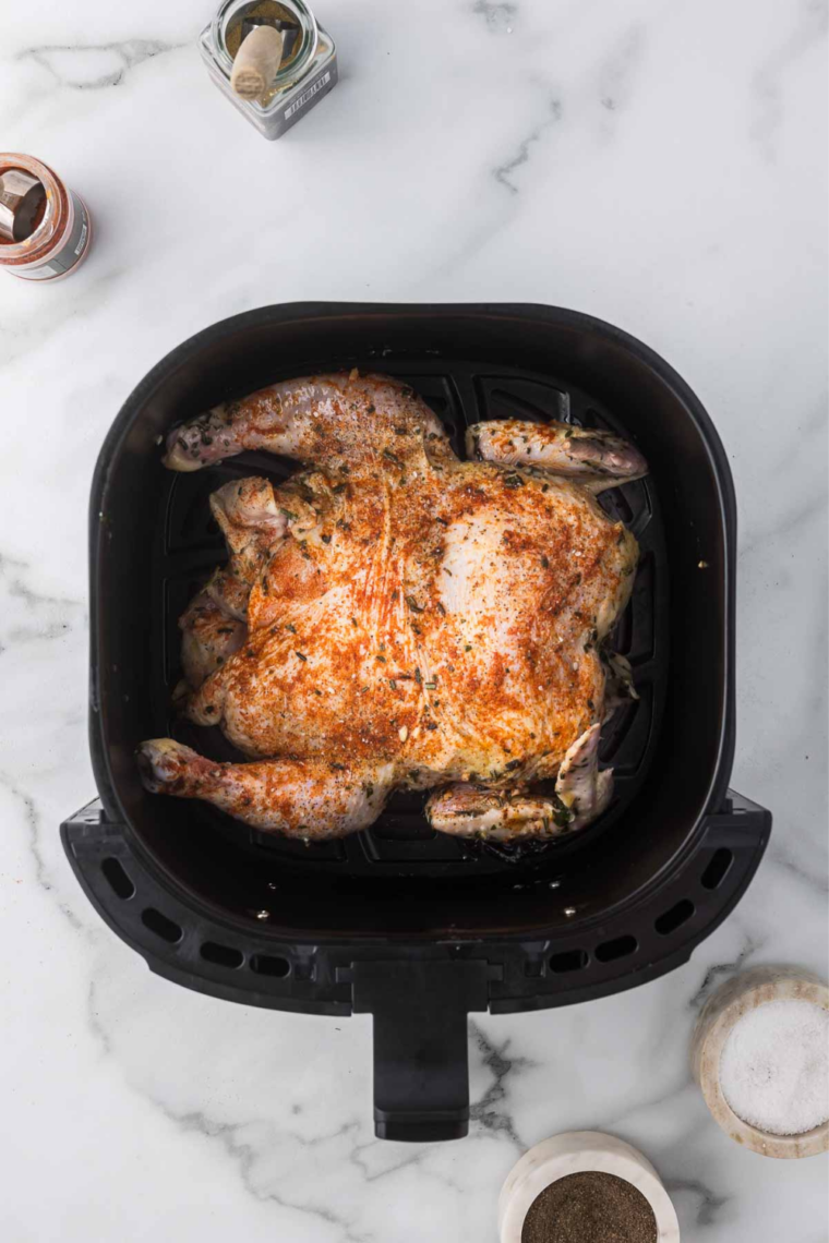 Seasoned spatchcock chicken in the air fryer basket