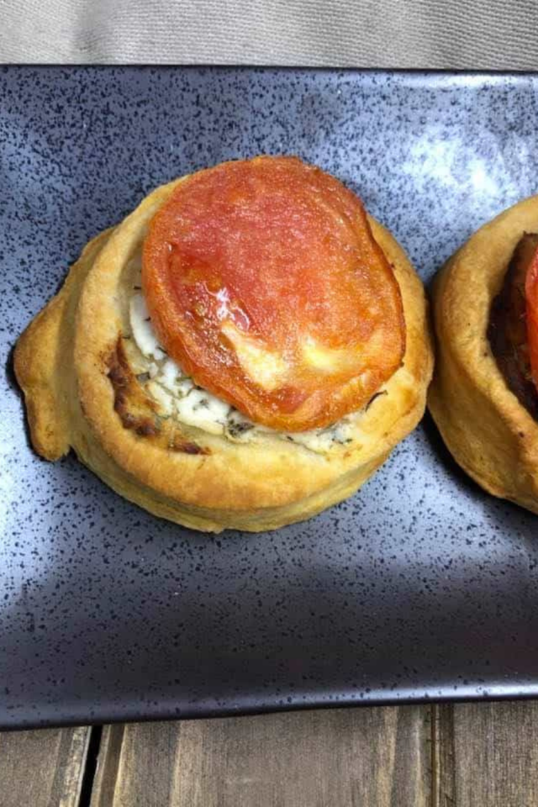 Finished air fryer goat cheese tomato tarts topped with basil and drizzled honey or balsamic glaze served warm