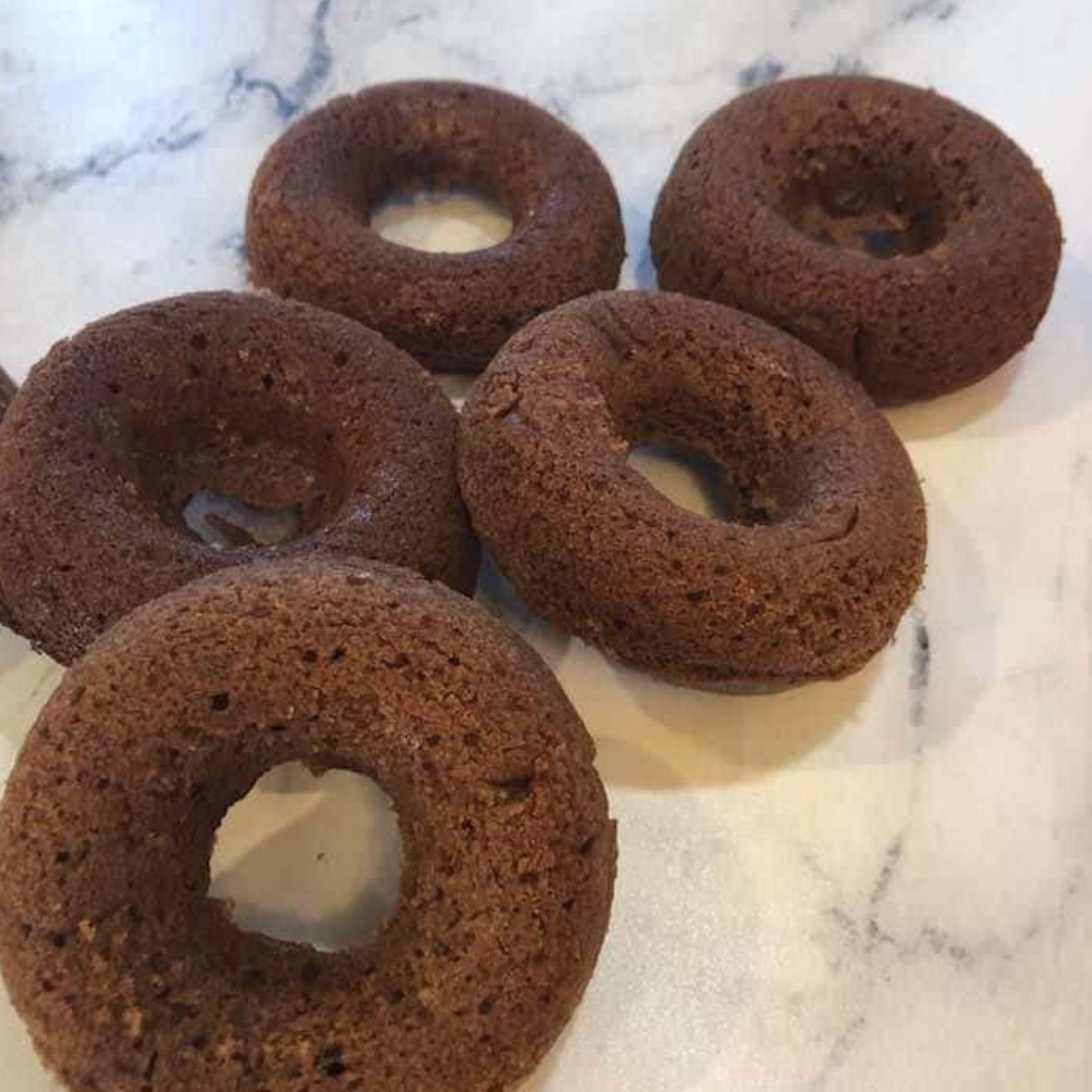 Cooked Dunkin' Donuts Chocolate Glazed Donuts on the kitchen counter.