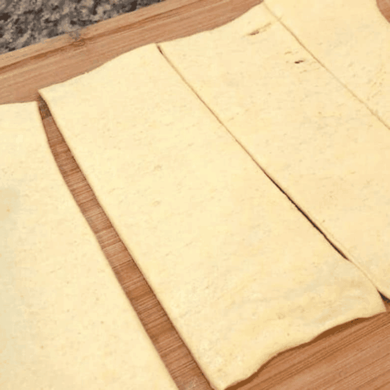 Crescent dough laid out on a surface, cut into four equal pieces ready for filling