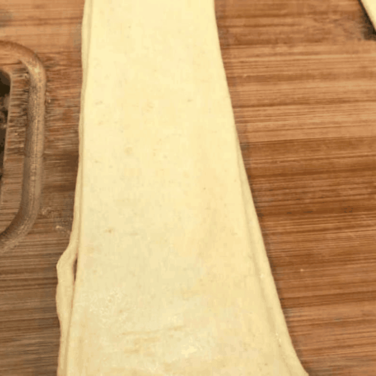 placing top crescent dough layer over apple filling and pressing edges to seal