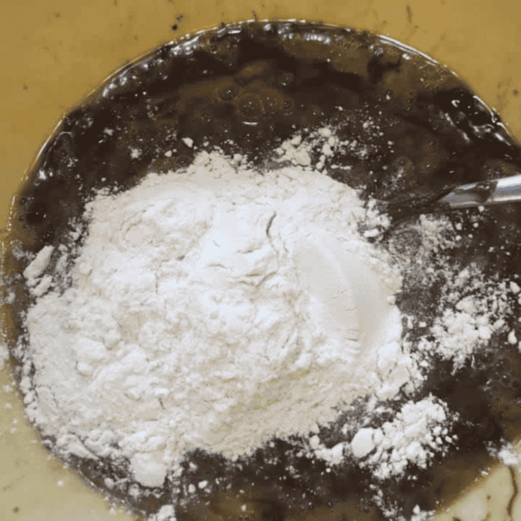 Stirring flour into Nutella and egg batter until combined.