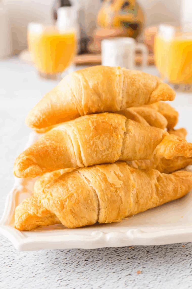 Golden-brown cheese stuffed crescent rolls on a baking sheet, brushed with garlic butter and sprinkled with herbs.