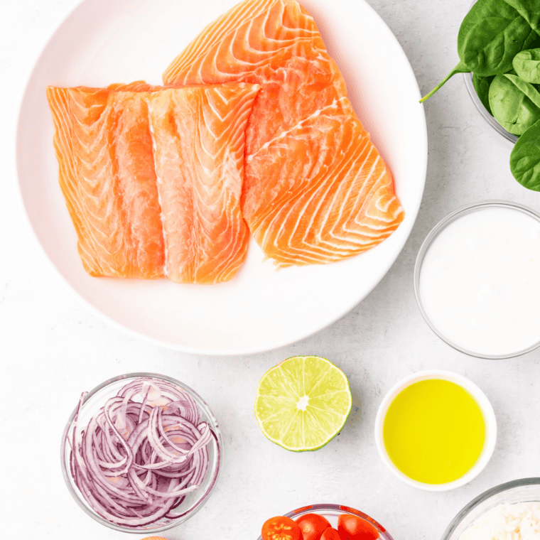 Air fryer honey lemon salmon ingredients on a table: salmon fillets, honey, lemon, garlic, soy sauce, and olive oil