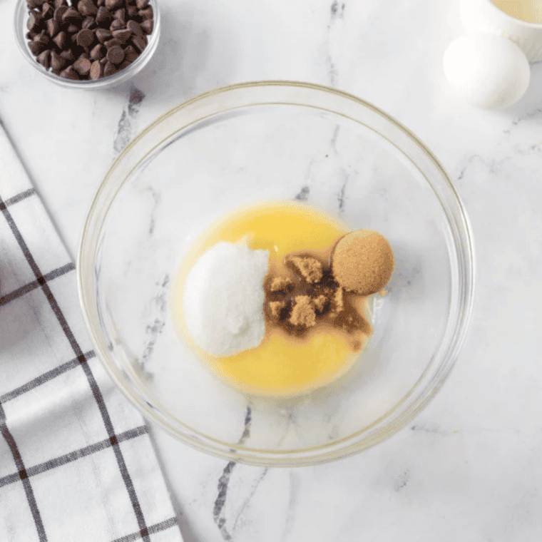 Creaming softened butter with brown sugar and granulated sugar in a small bowl to make cookie dough for chocolate chip cookies.