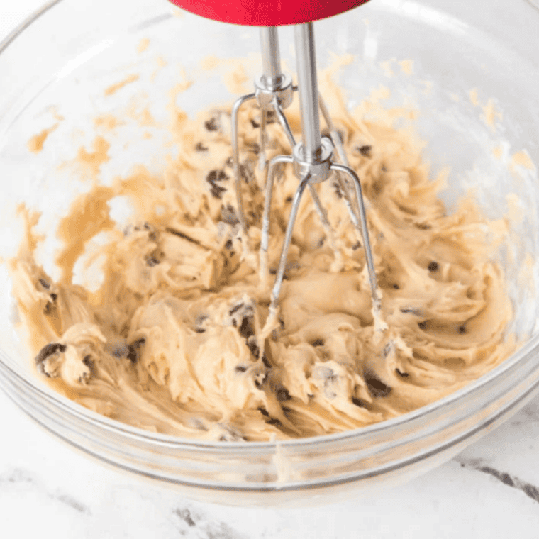 Chocolate chip cookie dough in a small mixing bowl ready to scoop into ramekins.