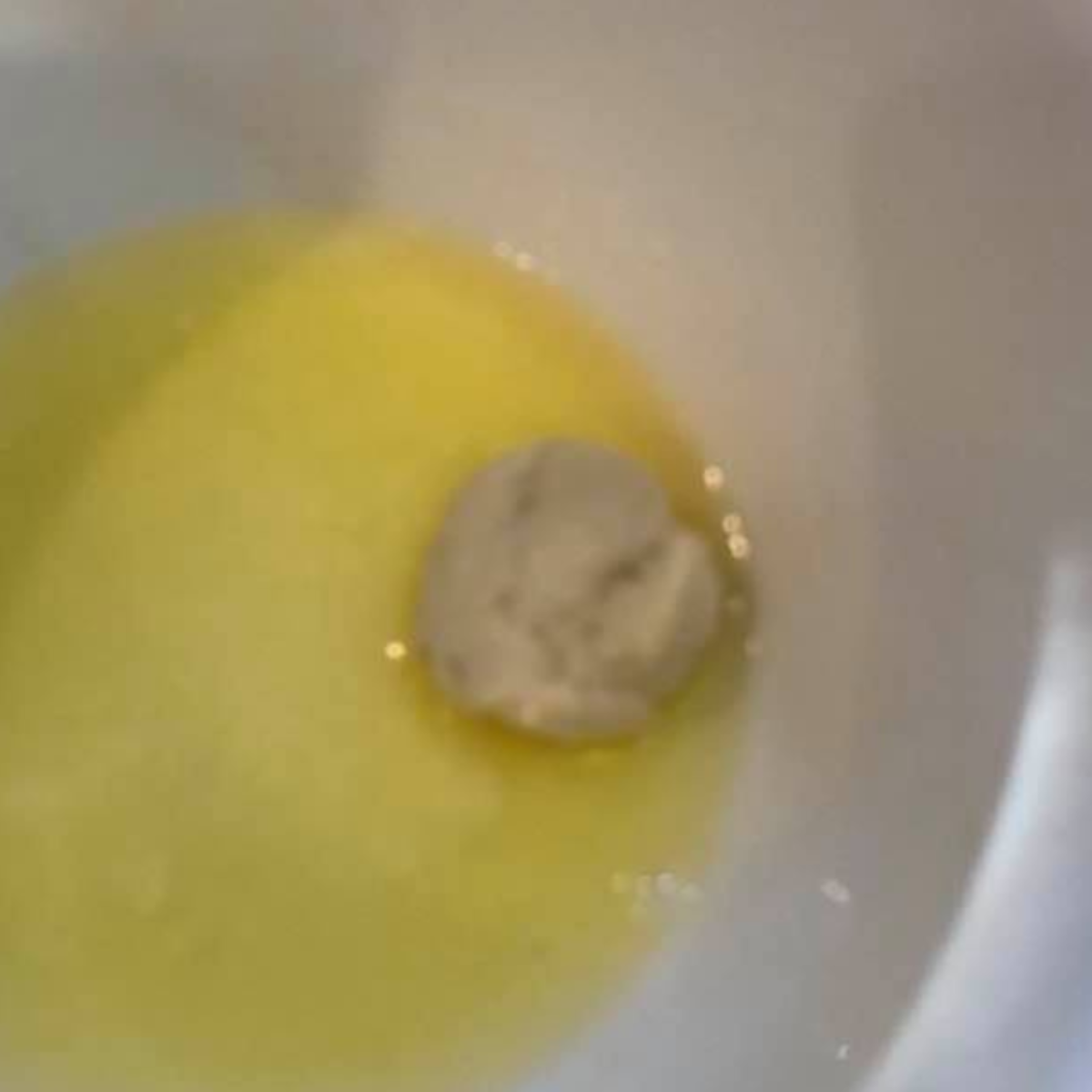 Cut biscuit dough pieces coated in melted butter for monkey bread