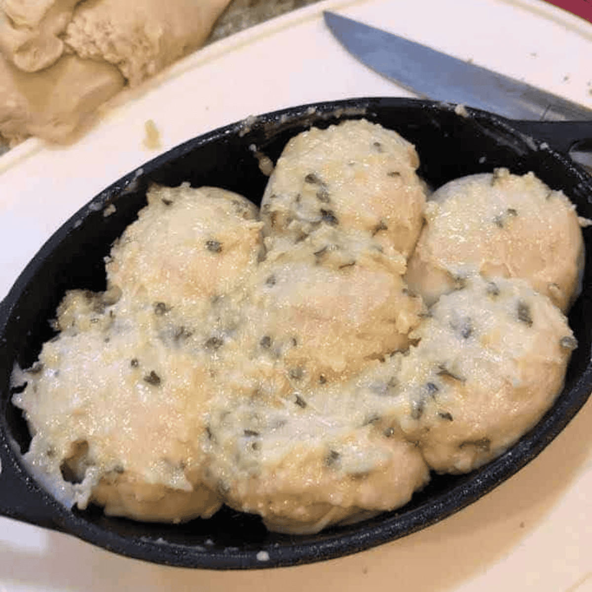 Air fryer basket with garlic Parmesan monkey bread baking in pan