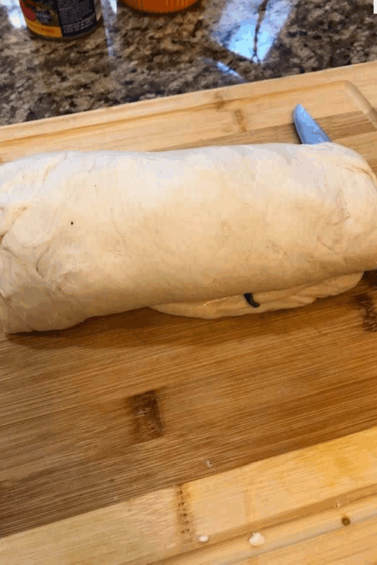 Prepared Spinach and Feta Stromboli on kitchen counter cutting board.