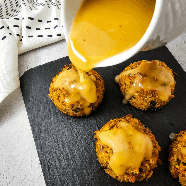 Individual servings of stuffing baked into muffin shapes, with a golden-brown crispy top, served on a platter.