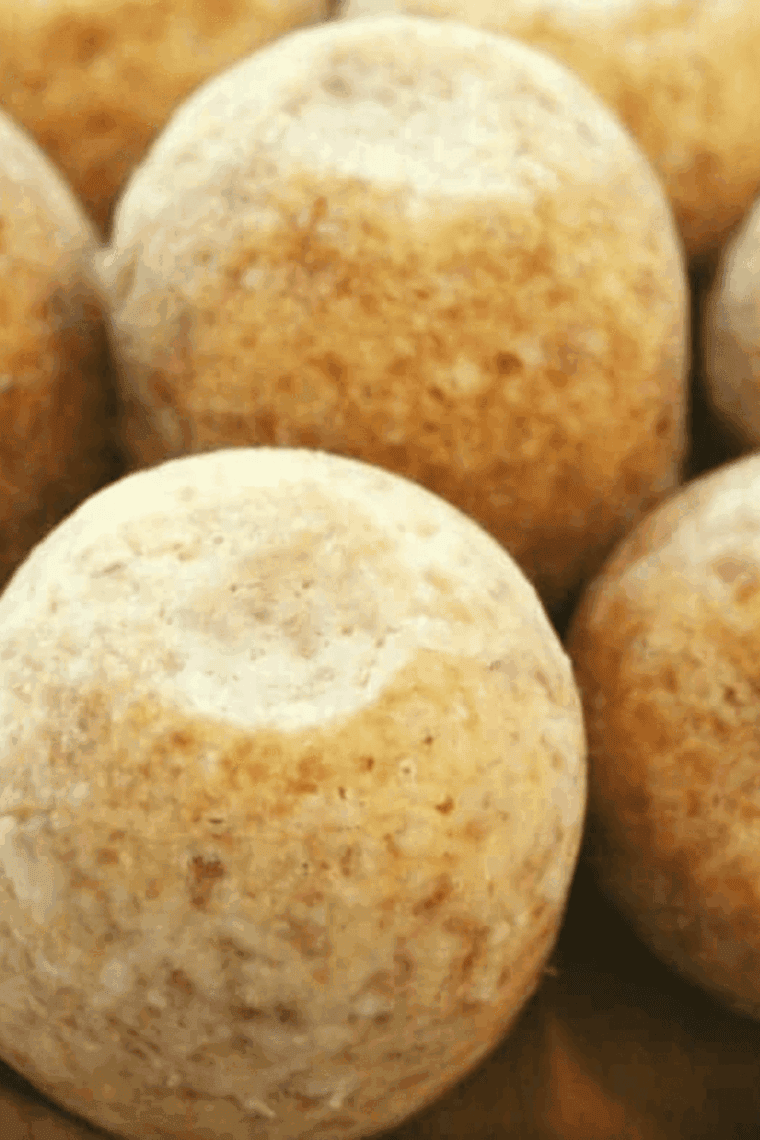 A white serving platter filled with moist, golden-brown gingerbread mini-muffins featuring a soft, cake-like texture.