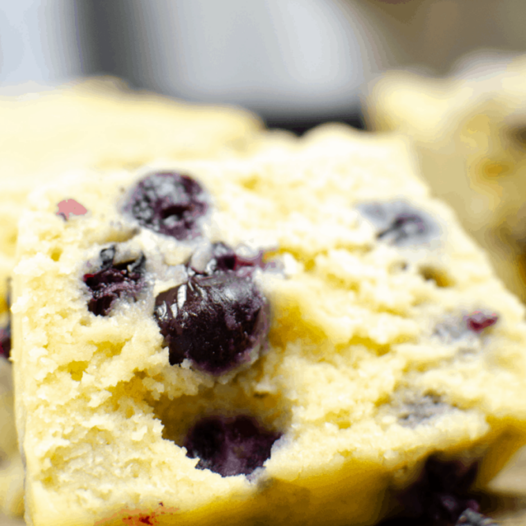 Mixing blueberries with flour in a small bowl to keep them from sinking in batter