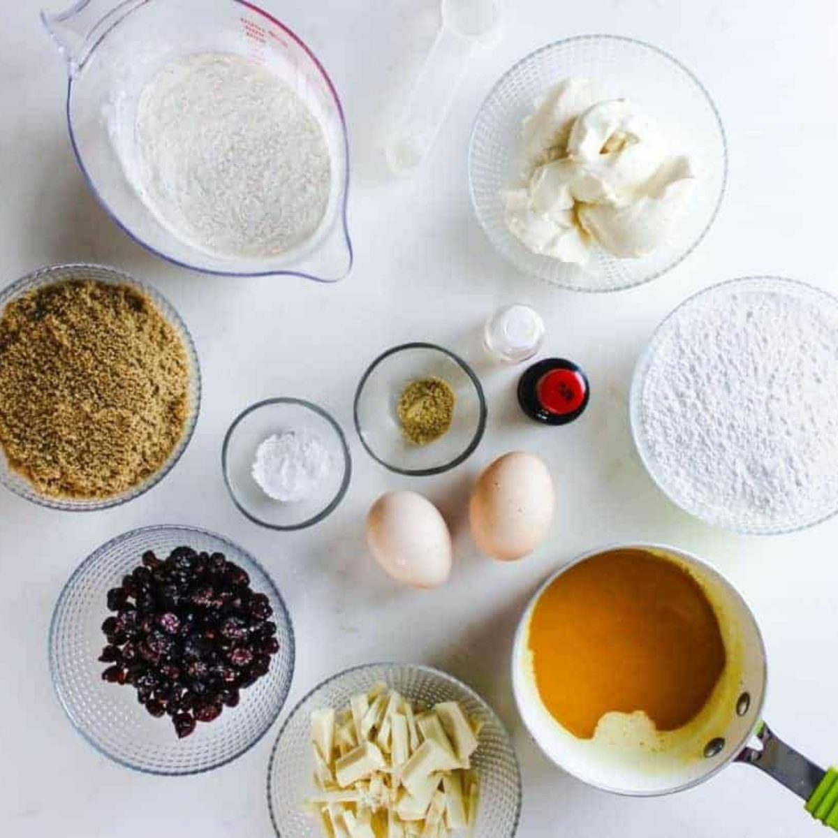 Ingredients for air fryer cranberry bliss bars including butter, brown sugar, eggs, flour, white chocolate chips, dried cranberries, and cream cheese