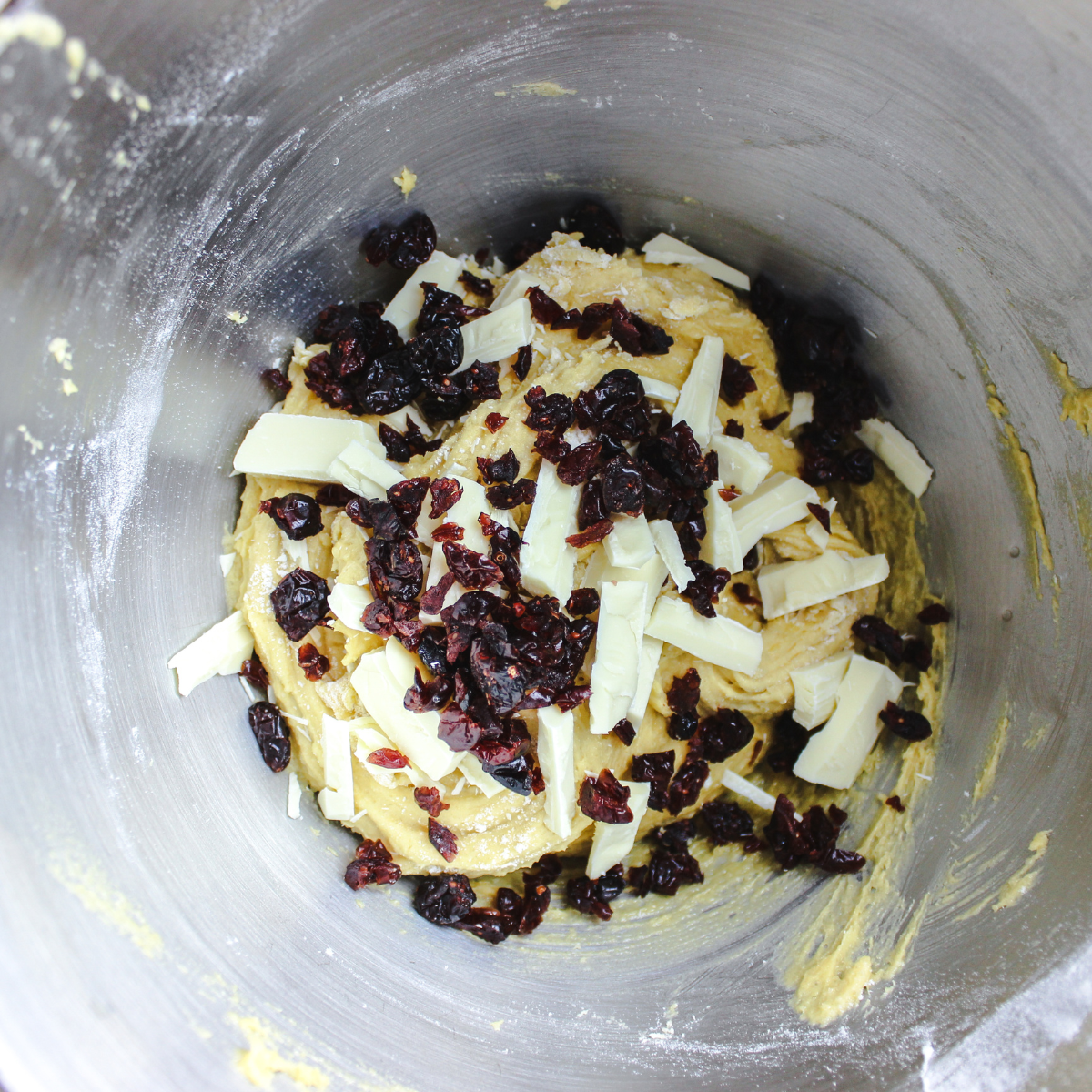 White chocolate chips and chopped dried cranberries folded into cranberry bliss bar batter