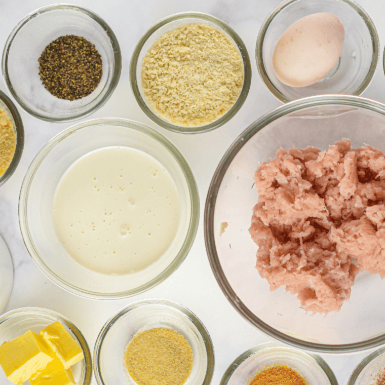 All ingredients for Alfredo meatballs laid out: ground chicken, panko, egg, Parmesan, garlic, and cream